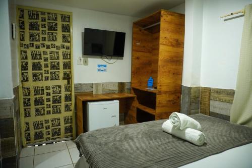 a bedroom with a bed with a television and a bed sidx sidx sidx at Pousada vila bela in Porto De Galinhas