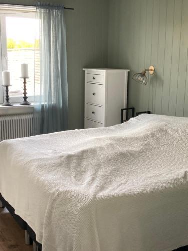 a bedroom with a bed and a dresser and a window at Känslans in Årjäng
