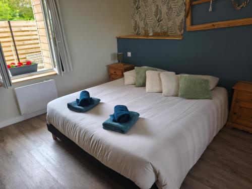 a bedroom with a large bed with blue towels on it at Gite de la perle rouge in Rodelinghem