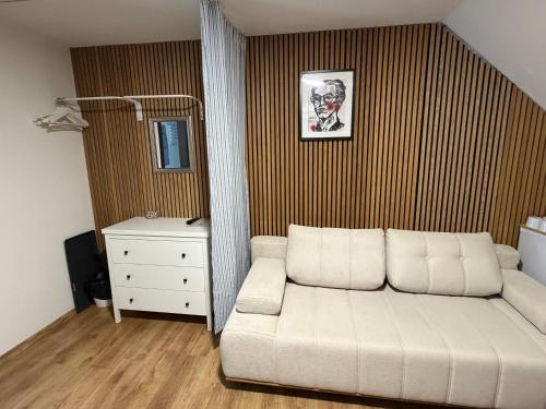 a living room with a white couch and a dresser at Slavia penzion in Mikulov