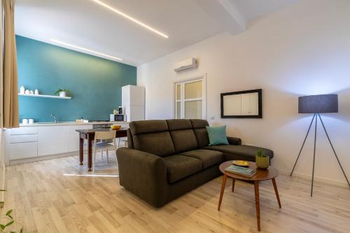 a living room with a couch and a table at RelaisApartments PORTO in Alghero