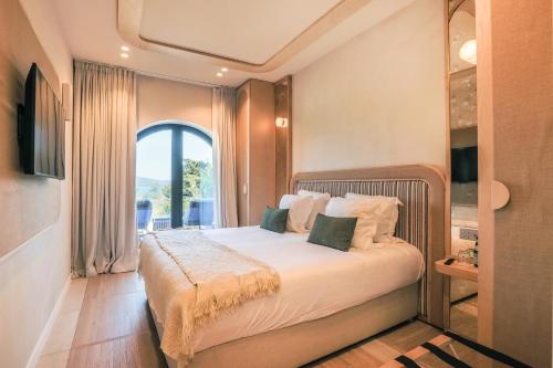 a bedroom with a bed with a large window at Maison Provence in Saint-Tropez