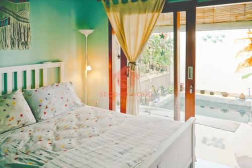a bedroom with a white bed and a large window at Unique 2BR Gianyar Villa Rice Field View & Pool in Blahbatu