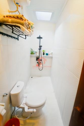 a bathroom with a white toilet in a room at Unique 2BR Gianyar Villa Rice Field View & Pool in Blahbatu
