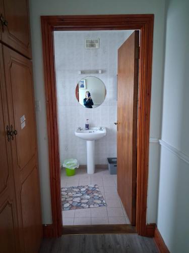 a person taking a picture of a bathroom with a sink at Teach Caitlin in Ballina