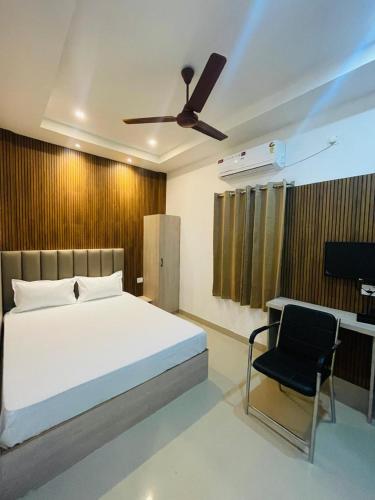 a bedroom with a bed and a black chair at Hotel STAYVILLA in Guwahati