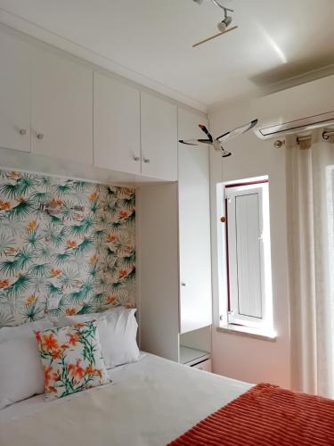 a bedroom with a white bed and a window at Casa das Andorinhas in Lagos