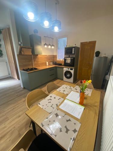 a kitchen with a wooden table with flowers on it at Andalics apartment in Kaposvár