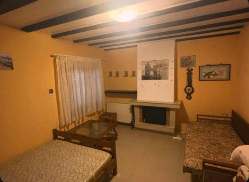 a living room with two beds and a fireplace at Greek Hacienda in Nea Kallikrateia