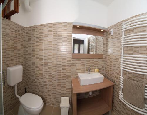 a bathroom with a toilet and a sink at La Siesta Bogács Apartman in Bogács