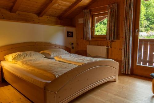a bed in a wooden room with a window at Apartments Bernard in Aldino