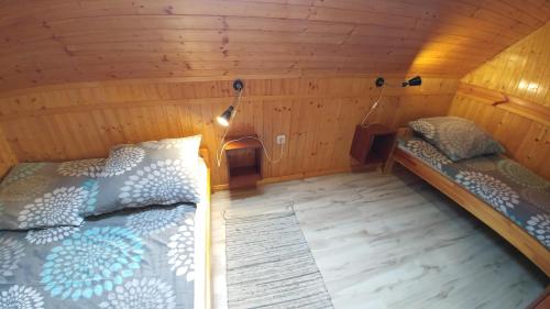 a bedroom with two beds in a wooden room at Dw Perła Sarbinowo in Sarbinowo