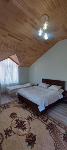 a bedroom with a large bed and a wooden ceiling at Comfort Hills in İsmayıllı