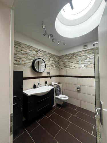 a bathroom with a sink and a toilet and a skylight at Ferienwohnung Fatlume No 6 in Bad Honnef am Rhein
