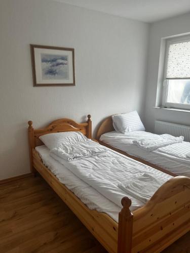two twin beds in a room with a window at Ferienwohnung Fatlume No 6 in Bad Honnef am Rhein