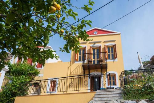 a yellow house with a balcony at Panoramic View House in Symi