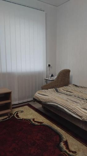 a bedroom with a bed and a table with a lamp at Котэдж Посуточно in Zhovti Vody