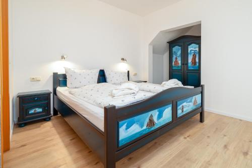 a bedroom with a large bed with two televisions at Strandläufer in Thiessow