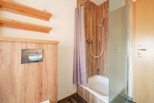 a bathroom with a shower and a bath tub at Leuchtfeuer in Thiessow