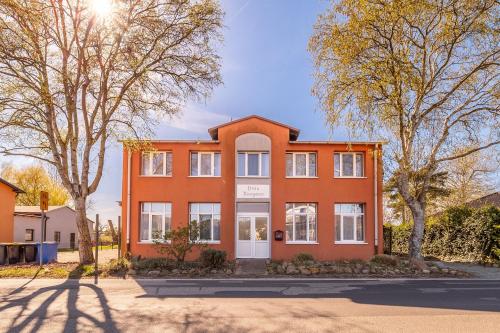 an orange house with trees in front of it at Heimathafen in Thiessow