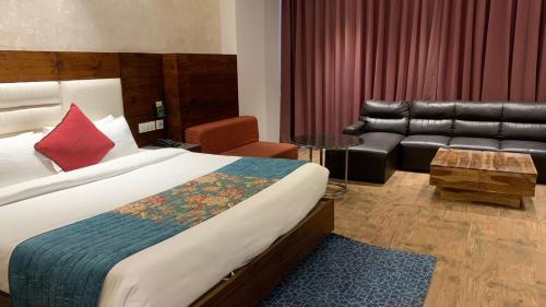 a hotel room with a bed and a couch at Palmdale Hotel & Resort in Ambāla