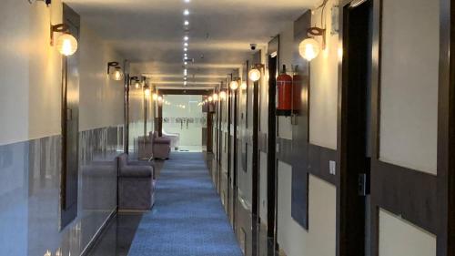 a long hallway with lights and a blue carpet at Palmdale Hotel & Resort in Ambāla