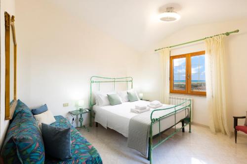 a bedroom with a bed and a couch at Tavolara Ichnos House in San Teodoro
