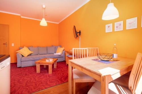 a living room with a blue couch and a table at Wellengang in Thiessow