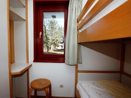 a bedroom with a bunk bed and a window at Ferien- & Freizeitpark Grafenhausen in Grafenhausen