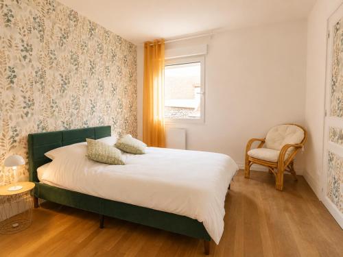 a bedroom with a bed and a chair and a window at Gîte cosy Vertus avec terrasse privé proche maisons de Champagne Epernay Reims in Vertus