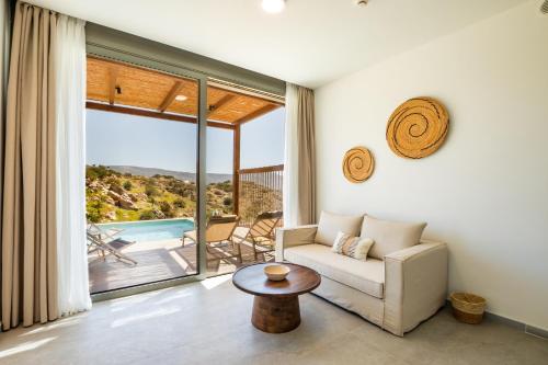 a living room with a couch and a table at Ramnus Karpathos Suites in Karpathos