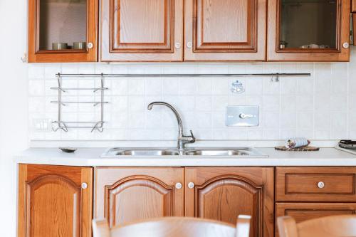 a kitchen with wooden cabinets and a sink at Molara Ichnos House in San Teodoro