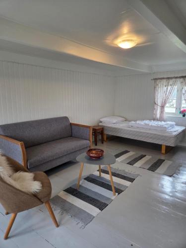 a living room with a couch and a bed at Fiskehuset Havnes in Averoy