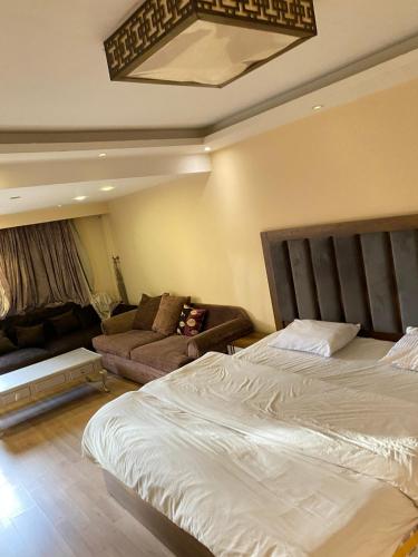 a bedroom with a bed and a couch at 18B Shehb Apartment Hotel in Giza
