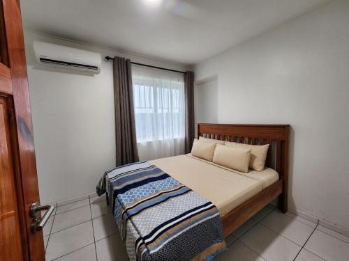 ein kleines Schlafzimmer mit einem Bett und einem Fenster in der Unterkunft Aurelia in Paramaribo