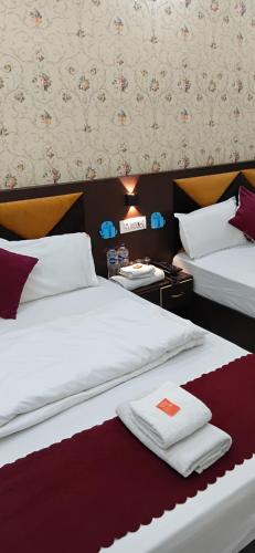 a hotel room with two beds with towels on them at Hotel Ramayanam palace in Ayodhya