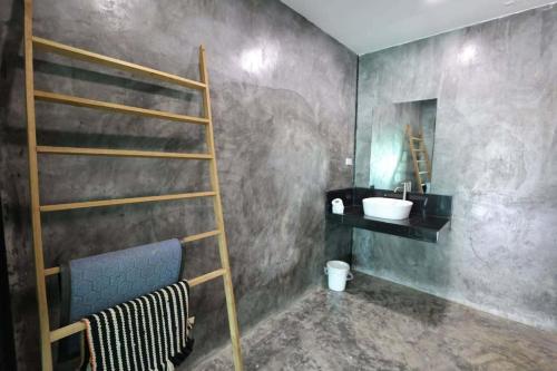a bathroom with a sink and a shelf and a ladder at มีดี ฟาร์ม โฮมสเตย์ in Ban Klam