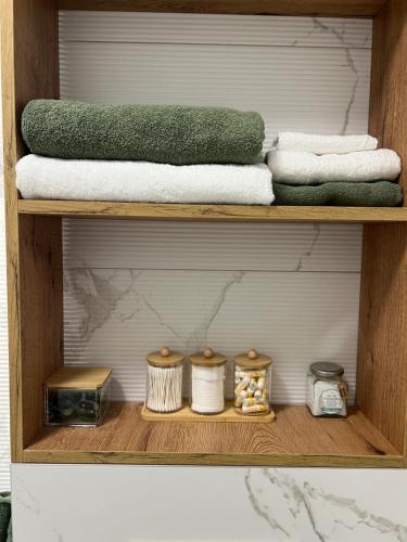 a shelf with towels and other items on it at Apartman 15 in Novi Sad