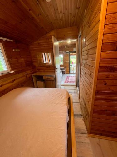 a small room with a bed in a wooden cabin at Naz Apartlari Cirali in Cıralı