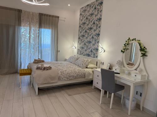 a bedroom with a bed and a desk and a mirror at Villa Asia Relais in Massa Lubrense