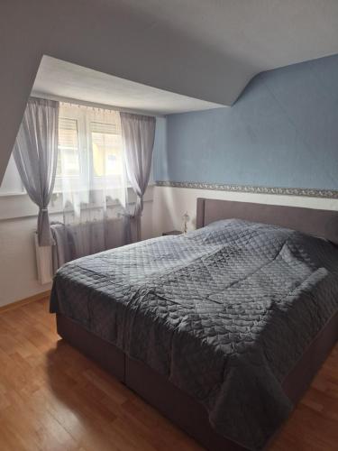 a bedroom with a bed and a window with curtains at Familienwohnung Bella in Pirmasens