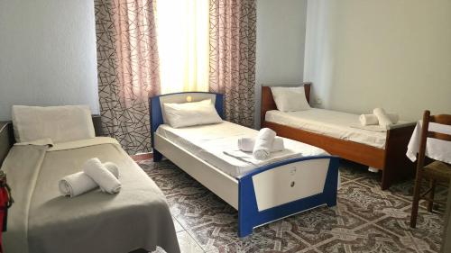 a room with two twin beds and a table at Guest house Sherifi in Berat