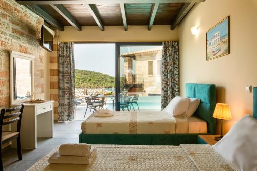 two beds in a room with a view of a patio at Ornella Beach Resort & Villas in Syvota