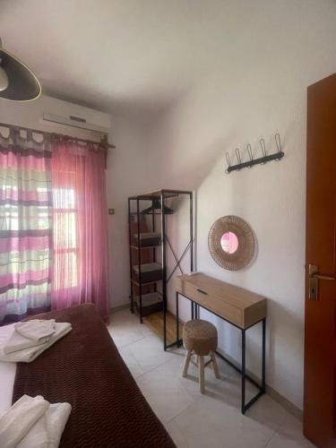 a bedroom with a bed and a desk and a window at Ariana's apartment in Orfánion