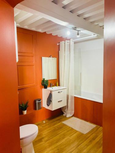 an orange bathroom with a toilet and a sink at Appartement hyper centre in Caen