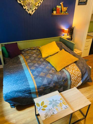 a bed in a room with a table next to it at Appartement hyper centre in Caen