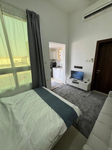 a bedroom with a bed and a window and a couch at روز للاستديوهات المفروشة in Abu Dhabi
