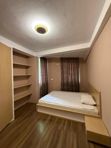 a small bedroom with a bed and shelves at Vila Tigani in Peje