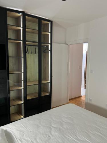 a bedroom with a bed and a glass closet at Apartman 15 in Novi Sad