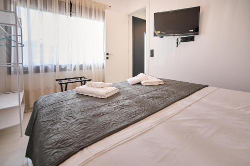 a bedroom with a large bed with two towels on it at Iraklia Coral in Nea Irakleia